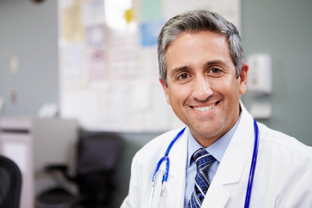 A doctor smiling for the camera in his office.